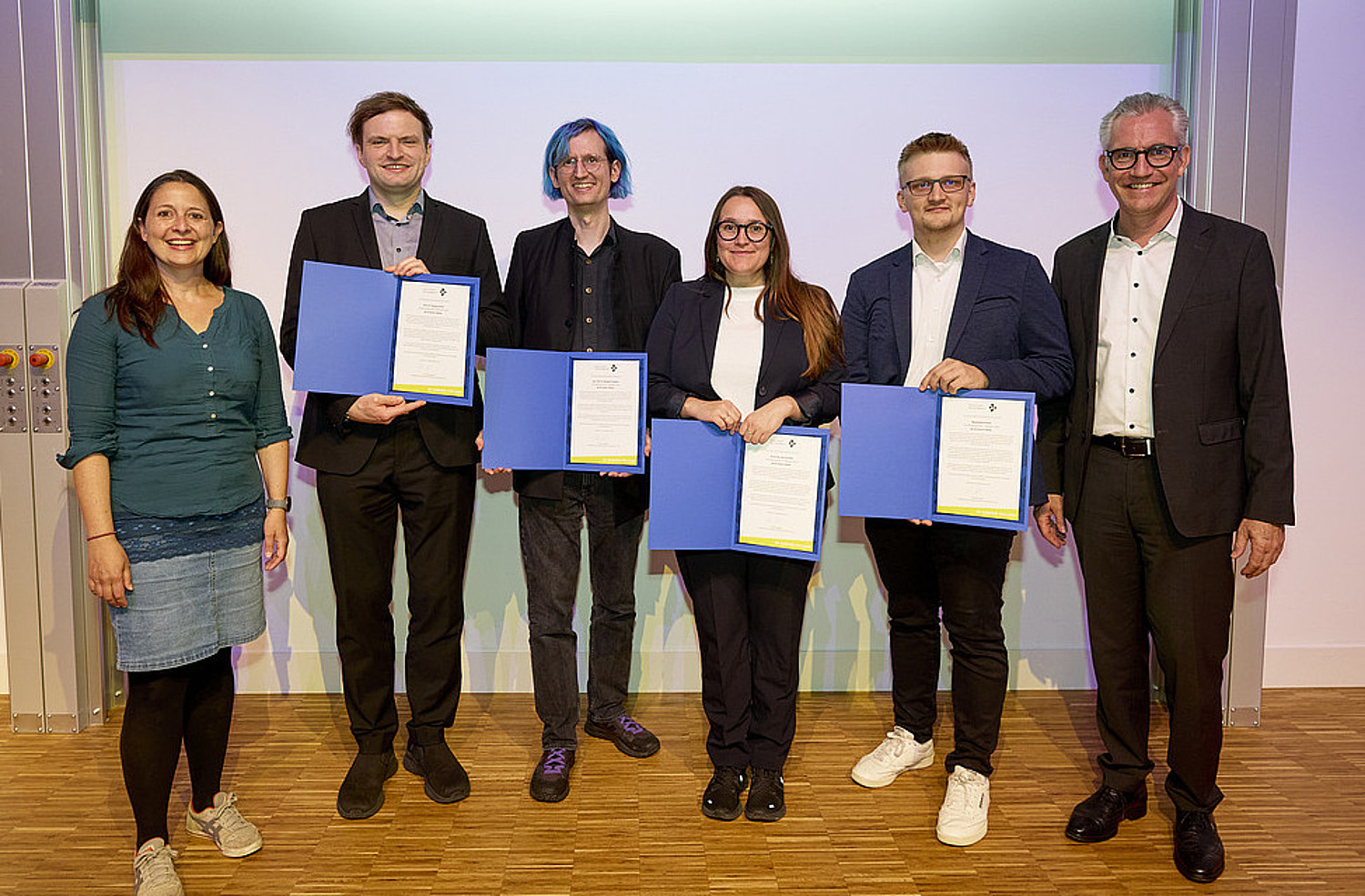 Vorstandsmitglied Nadine Bergner, die vier Junior-Fellows Thomas Kosch, Benjamin Paaßen, Vera Schmitt und Maximilian Kroker und GI-Präsident Martin Wolf bei der Überreichung der Urkunden.