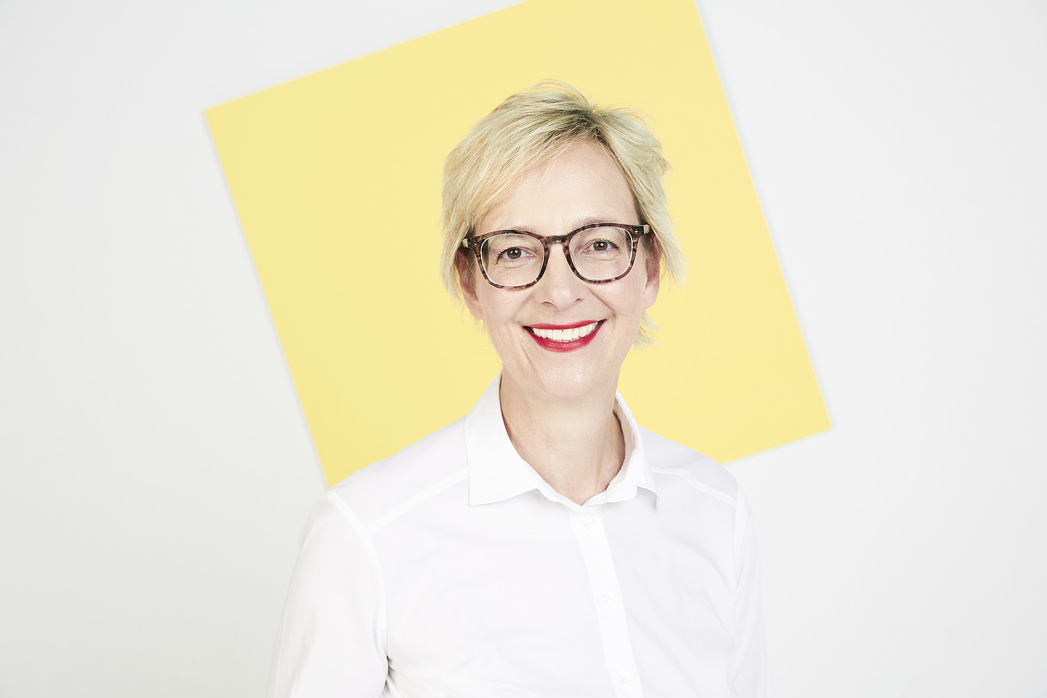 Porträt von Christine Regitz vor einem gelben Quadrat